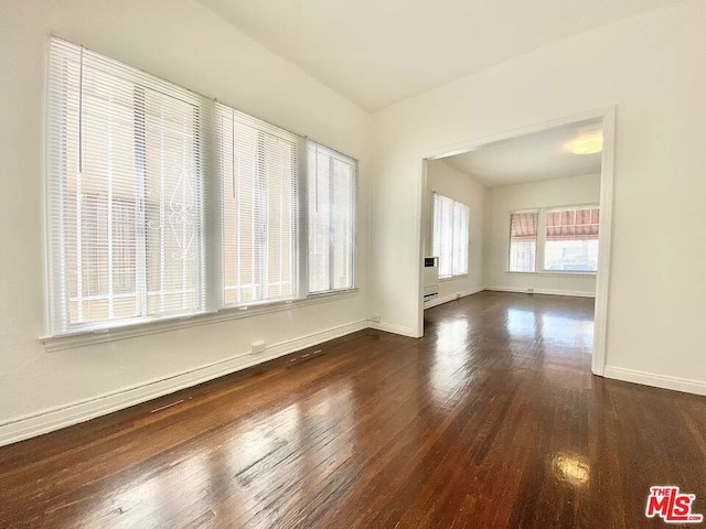 unfurnished room with dark hardwood / wood-style flooring