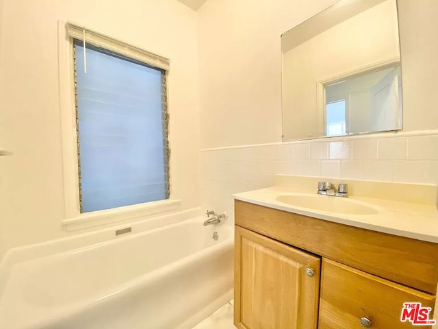 bathroom featuring backsplash and vanity with extensive cabinet space