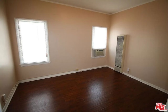 empty room with ornamental molding and dark wood-type flooring