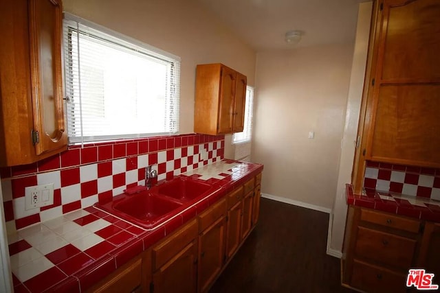 kitchen featuring tile countertops, tasteful backsplash, and sink