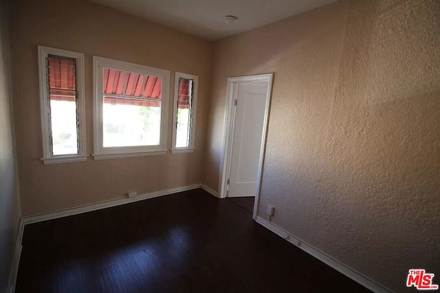 empty room featuring dark hardwood / wood-style flooring