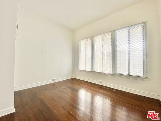 spare room with dark hardwood / wood-style flooring