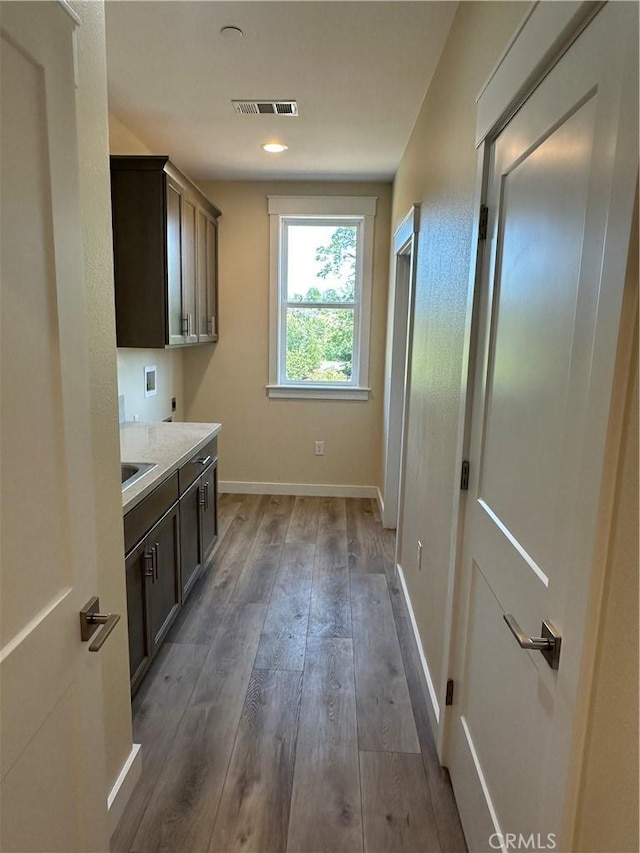 washroom featuring dark hardwood / wood-style flooring, washer hookup, cabinets, and hookup for an electric dryer