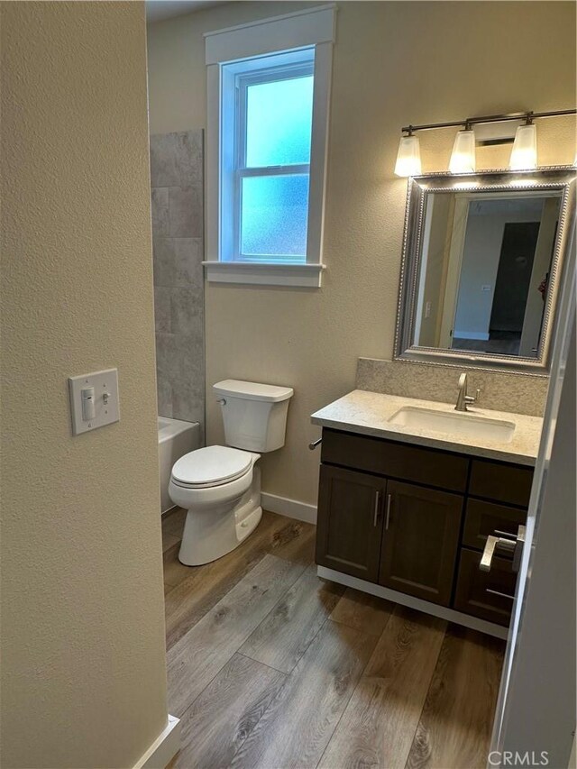 full bathroom featuring bathtub / shower combination, vanity, hardwood / wood-style flooring, and toilet