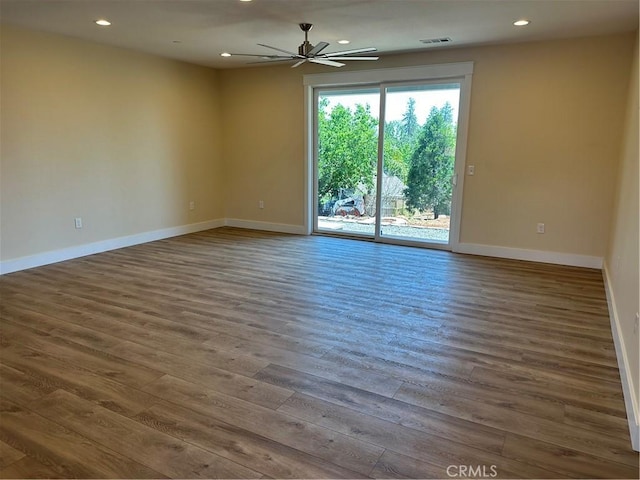 unfurnished room with dark hardwood / wood-style flooring and ceiling fan