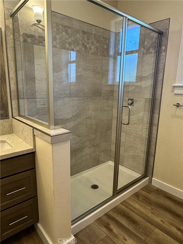 bathroom with vanity, walk in shower, and hardwood / wood-style floors