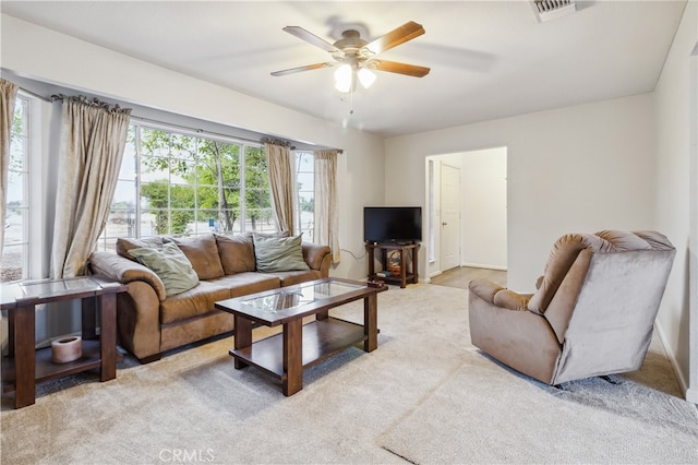 carpeted living room with ceiling fan