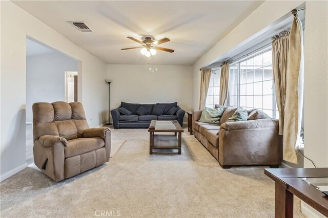 carpeted living room with ceiling fan