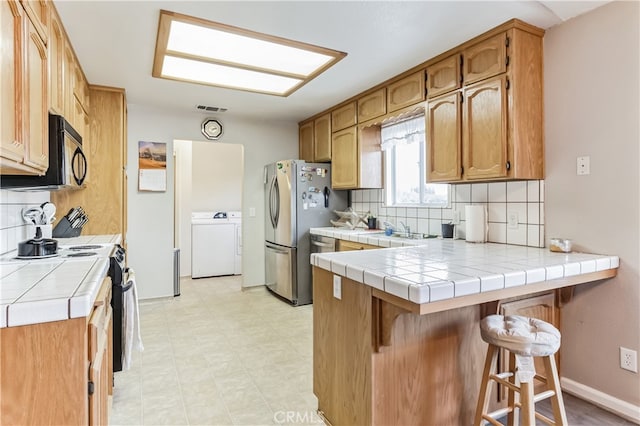 kitchen with backsplash, tile countertops, white electric range oven, and a kitchen bar