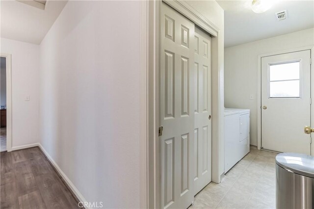 hallway featuring independent washer and dryer and light tile flooring