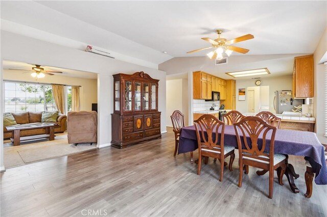 dining room featuring lofted ceiling, ceiling fan, and hardwood / wood-style flooring