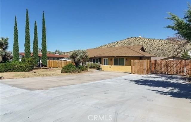 ranch-style home with stucco siding and fence