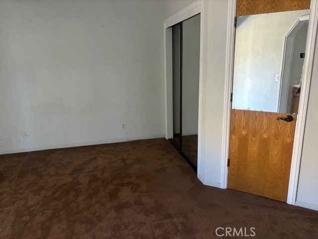 unfurnished bedroom with dark carpet