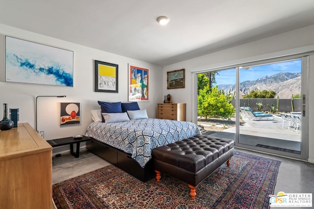 bedroom featuring a mountain view, concrete floors, and access to outside