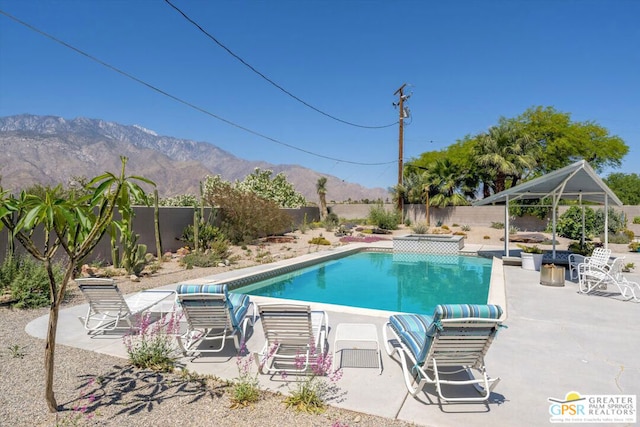 view of swimming pool with a gazebo, a patio area, and a mountain view