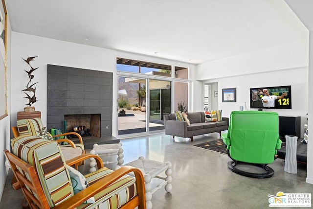 living room with a tiled fireplace and concrete floors