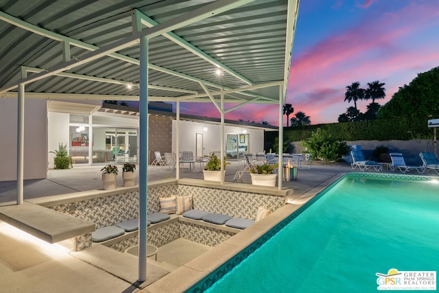 pool at dusk with a patio