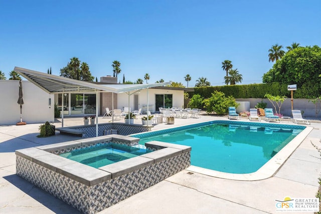 view of swimming pool featuring a patio area and an in ground hot tub