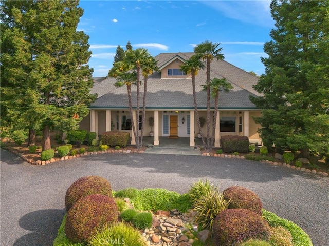 view of front of home featuring covered porch, driveway, and stucco siding