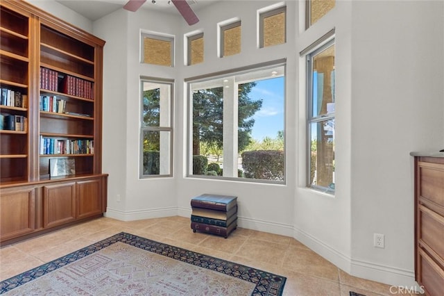 unfurnished room featuring ceiling fan, baseboards, and light tile patterned flooring