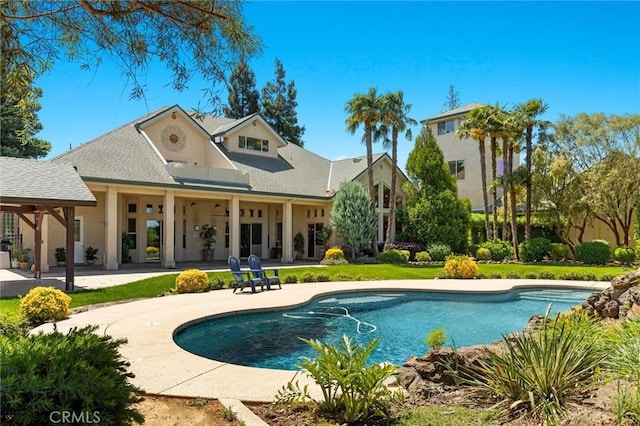 rear view of house with a patio area and an outdoor pool