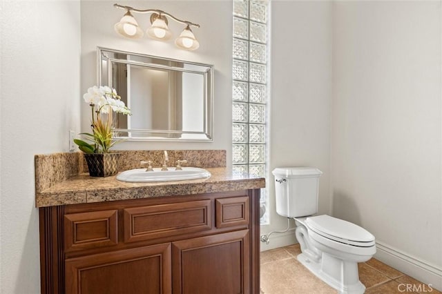 bathroom with baseboards, vanity, toilet, and tile patterned floors