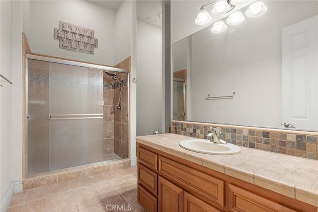 bathroom featuring a stall shower, tile patterned floors, decorative backsplash, and vanity