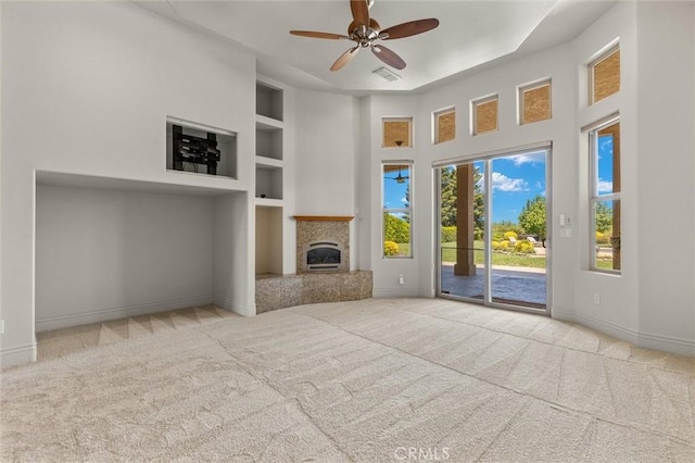 unfurnished living room with built in features, light carpet, and baseboards