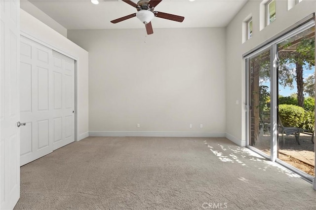 unfurnished room featuring carpet floors, ceiling fan, and baseboards