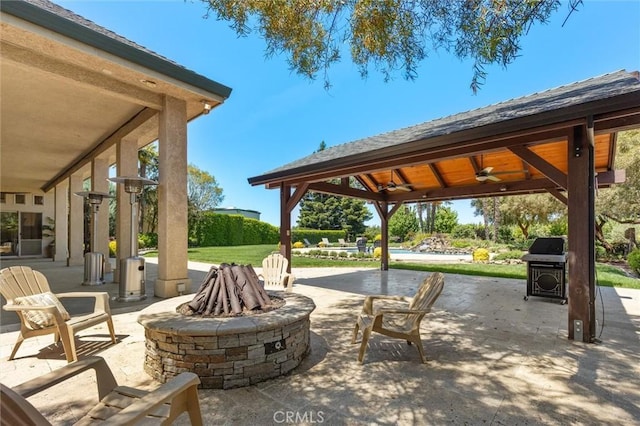 view of patio with a ceiling fan, a fire pit, area for grilling, and a gazebo