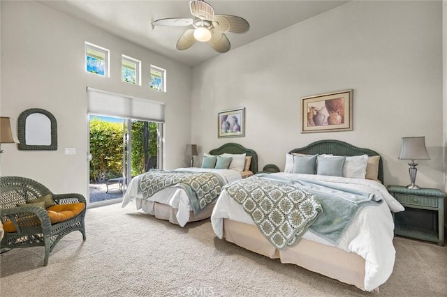 bedroom with ceiling fan, access to outside, carpet floors, and a towering ceiling