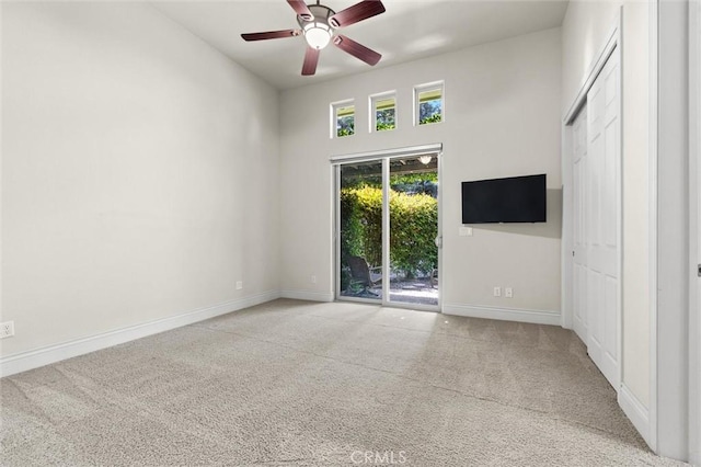 empty room featuring light carpet, baseboards, and a ceiling fan