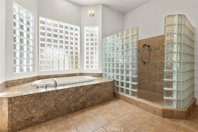 bathroom with tile patterned floors, a garden tub, and walk in shower