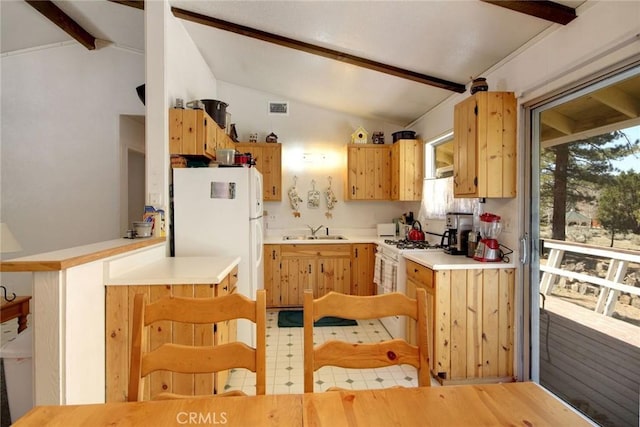 kitchen with kitchen peninsula, sink, lofted ceiling with beams, and white appliances