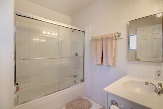 bathroom with shower / bath combination with glass door, vanity, and tile patterned flooring