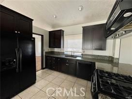 kitchen with dark brown cabinetry, sink, ventilation hood, light tile patterned floors, and black appliances