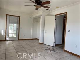 spare room with crown molding, light tile patterned floors, and ceiling fan