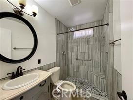 bathroom with a shower, vanity, and toilet