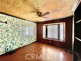 unfurnished room with ceiling fan and wood-type flooring