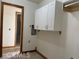 washroom with light tile patterned flooring and cabinets