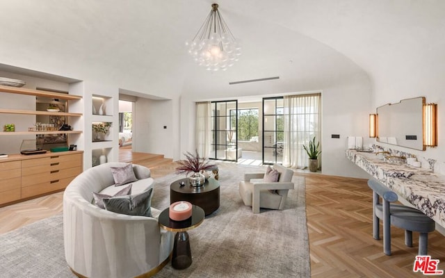 living room featuring light parquet floors, an inviting chandelier, and built in shelves