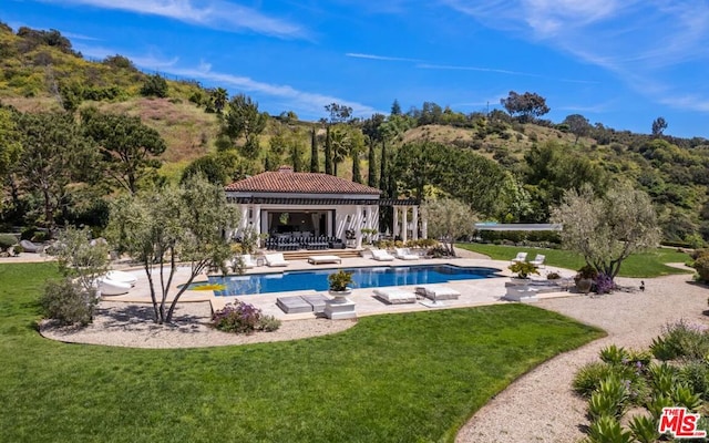 view of swimming pool featuring a patio area and a lawn