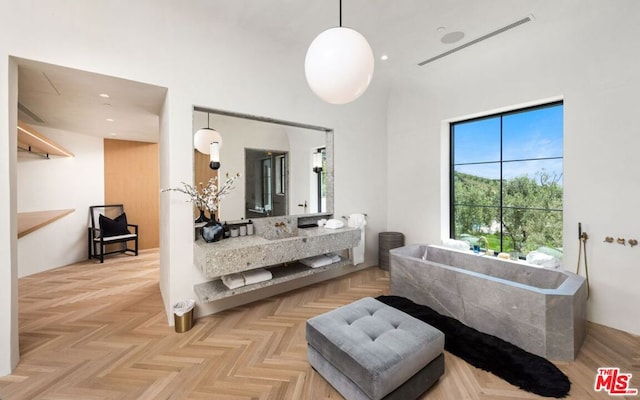 bathroom featuring parquet floors, a tub to relax in, and vanity