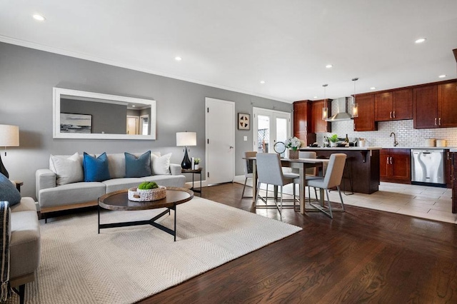 living room with hardwood / wood-style flooring, crown molding, and sink