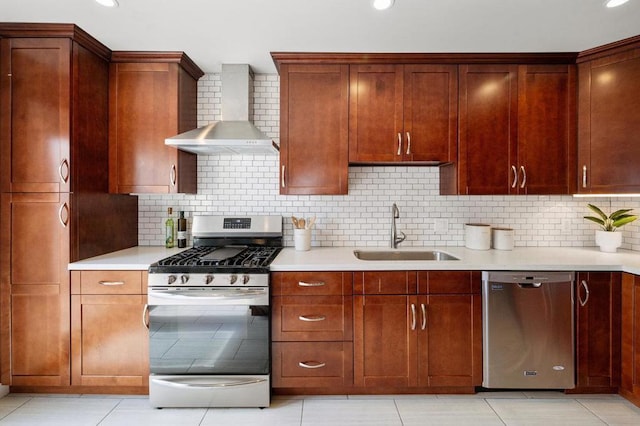 kitchen with appliances with stainless steel finishes, wall chimney range hood, backsplash, and light tile floors