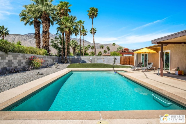 view of swimming pool featuring a mountain view and a patio