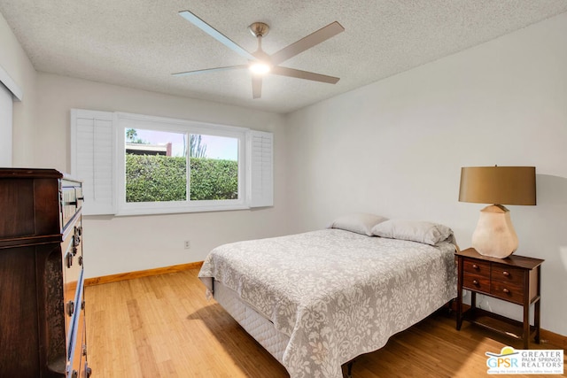 bedroom with ceiling fan, a textured ceiling, and light wood-type flooring