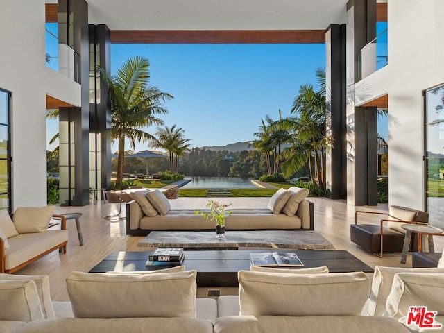 living room with a water view, a wealth of natural light, and hardwood / wood-style floors