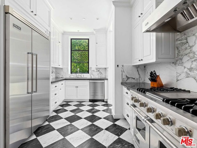 kitchen featuring white cabinets, backsplash, custom range hood, high quality appliances, and dark tile flooring