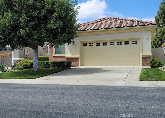 view of front of property featuring an attached garage, brick siding, a tile roof, concrete driveway, and stucco siding